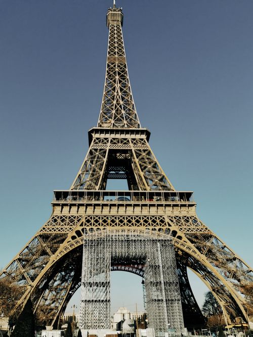 Free Eiffel Tower under clear skies in Paris, a must-see tourist destination. Stock Photo