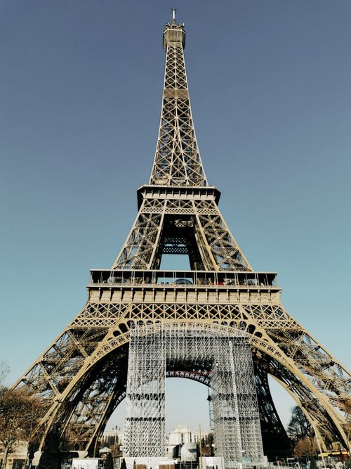 Free Stunning low-angle view of the Eiffel Tower with a clear blue sky backdrop, perfect for travel inspiration. Stock Photo