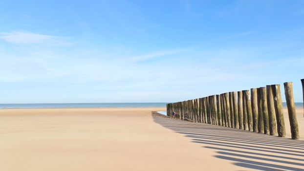 Serene beach landscape with wooden posts at La Côte, Bourgogne-Franche-Comté, France.