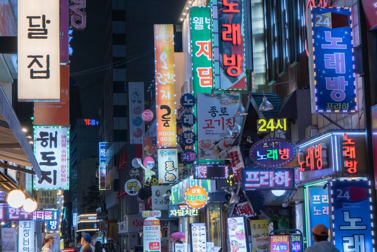 한글 네온 간판이 빽빽한 서울 번화가 먹자골목의 밤 풍경