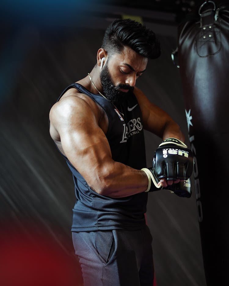 Photo Of A Brunette Muscular Man With A Punch Bag