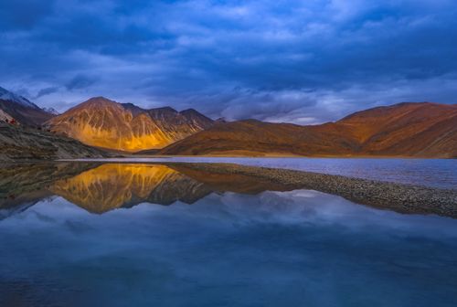 Free Stunning view of Leh mountains reflected in a tranquil lake at sunset. Stock Photo