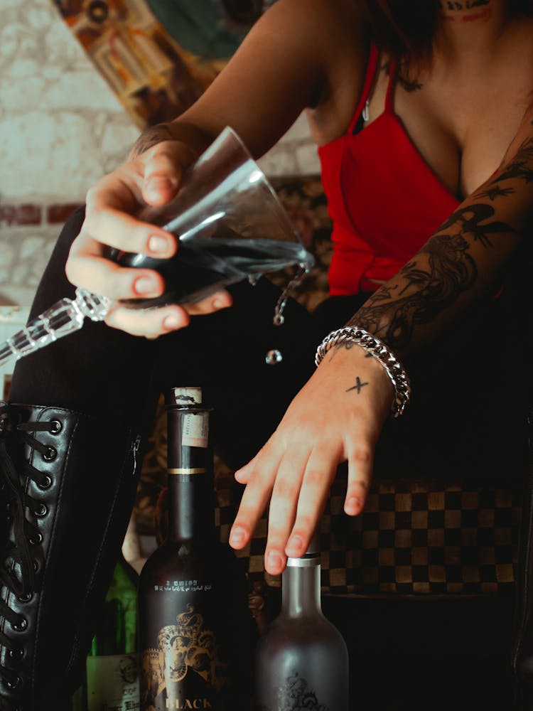 Woman In Red Spaghetti Strap Top Pouring A Glass Of Wine