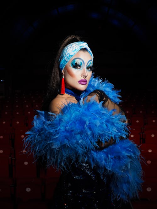 Woman Wearing Creative Makeup Wrapped in Blue Feather 