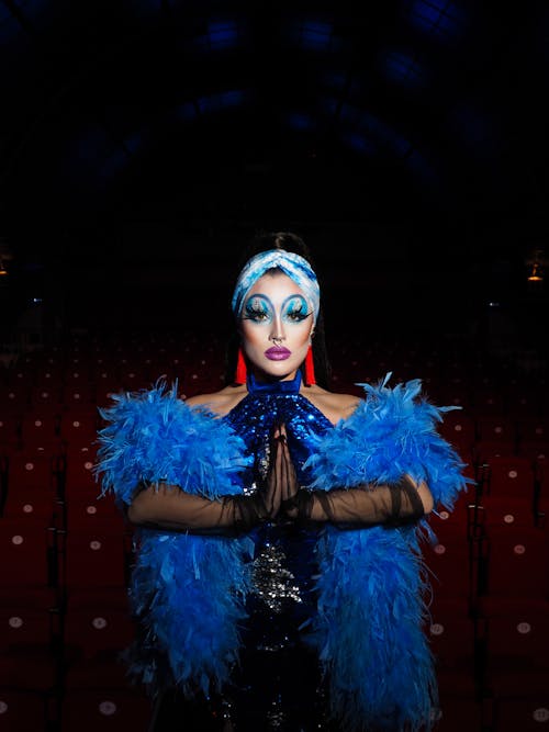 Woman Wearing Creative Makeup Wrapped in Blue Feather 