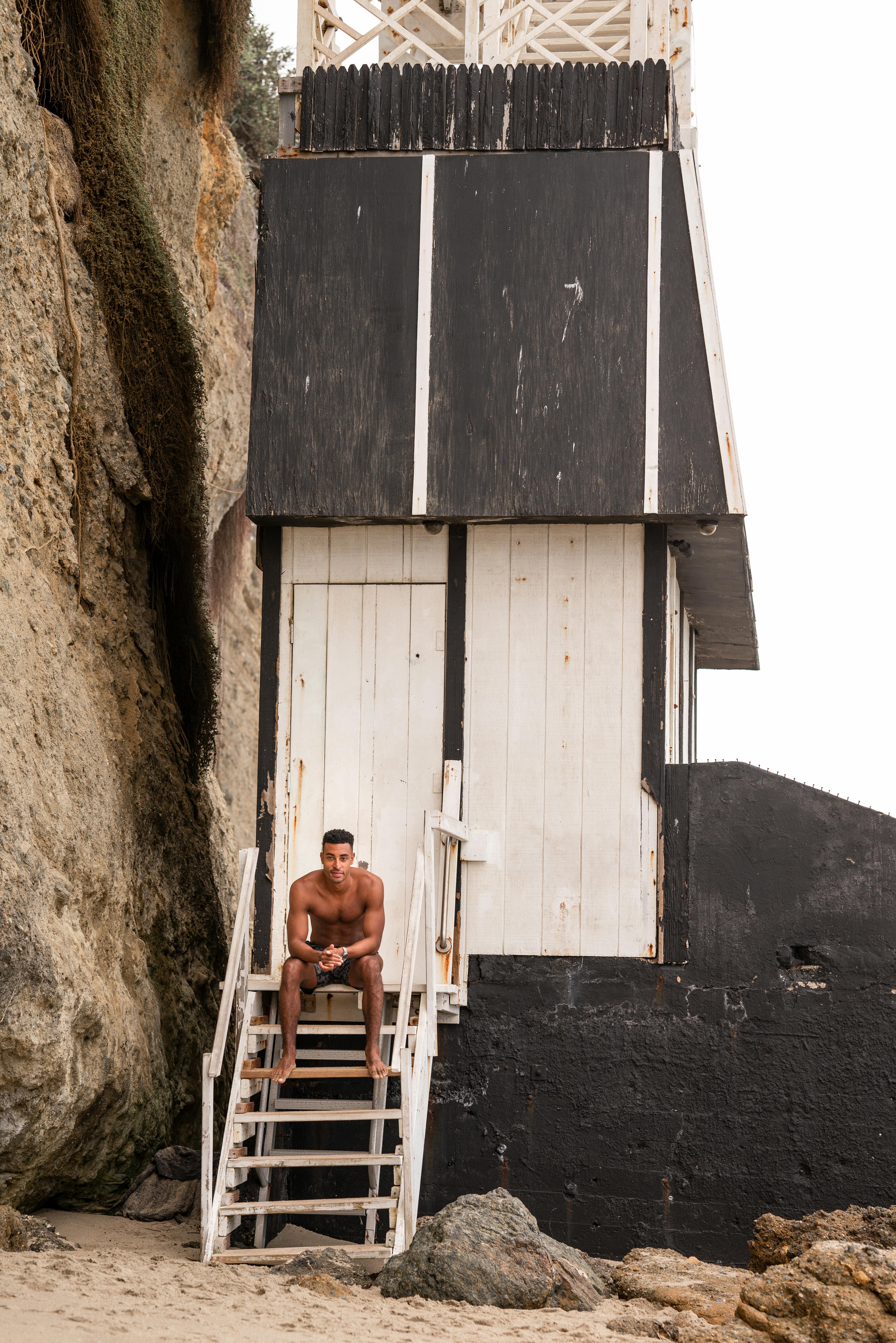 man sitting on the stairs leading to a cliff of laguna beach