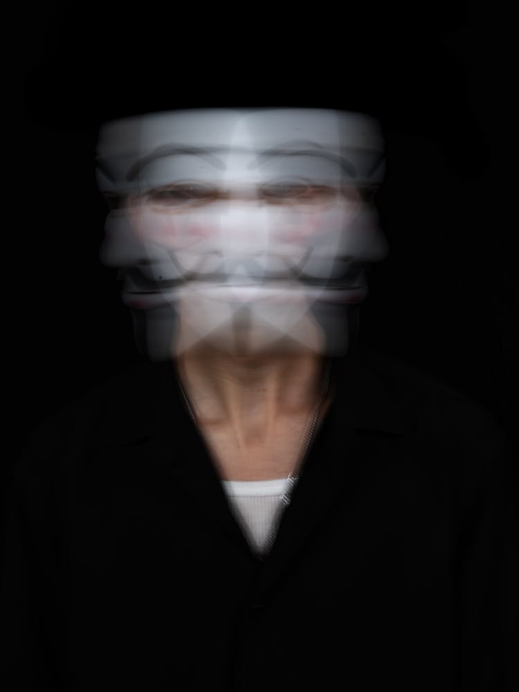 A Blurry Photo Of A Person With A Mask