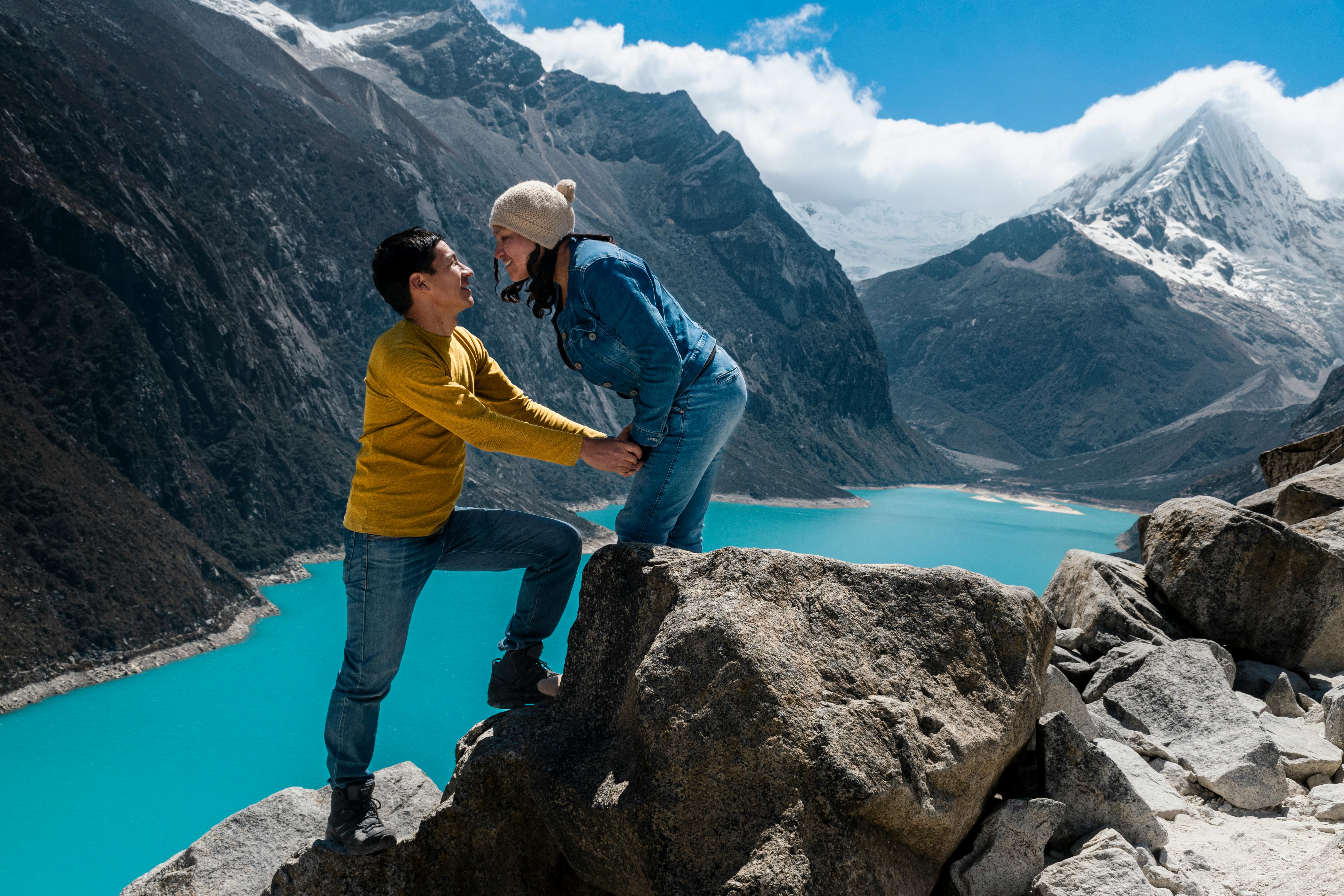 Couple exploring the majestic snowy mountains and turquoise lakes of Huaraz, Peru.