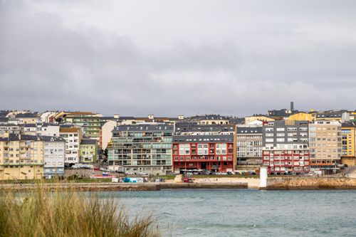 Free Colorful townhouses along Foz's waterfront in Galicia, Spain, on an overcast day. Stock Photo