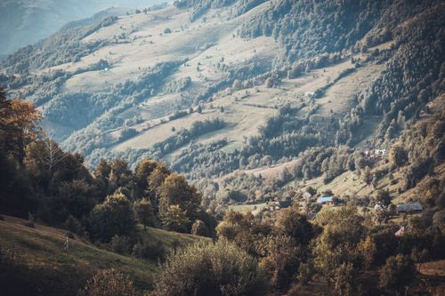 Free Beautiful mountain landscape with rolling hills and scattered houses in daylight. Stock Photo