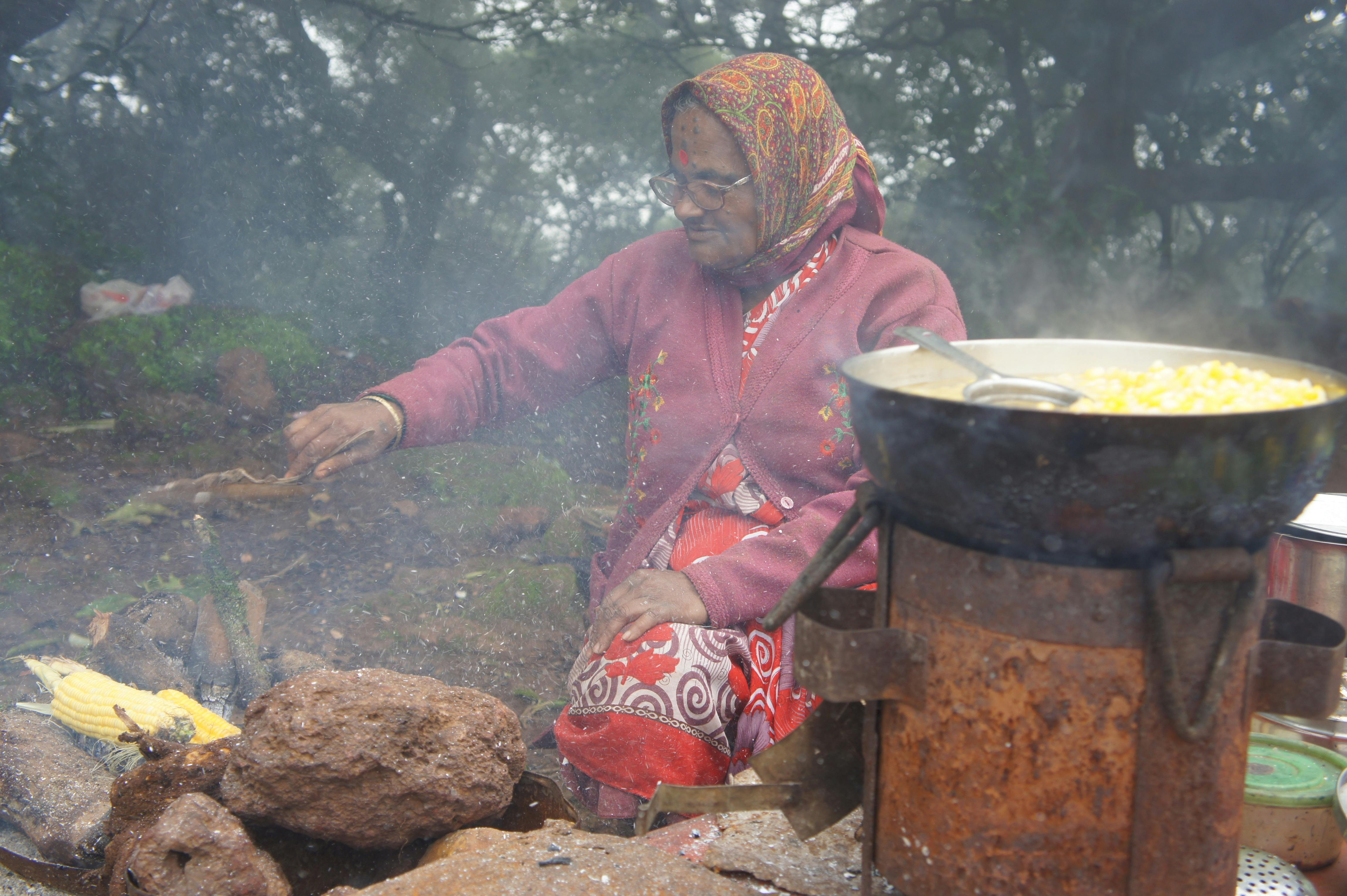 Free stock photo of indian lady cooking corn on fire