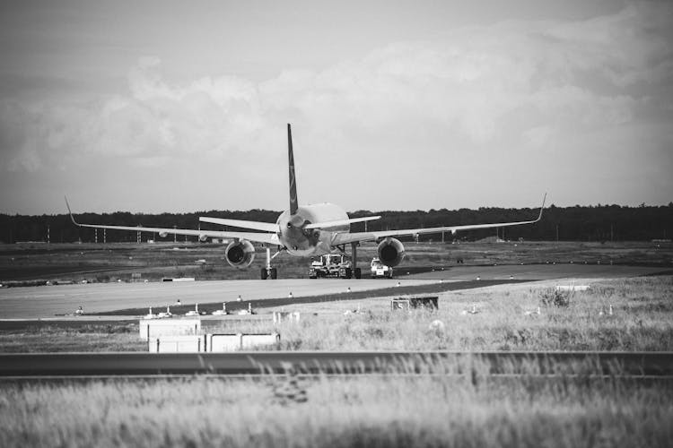 Grayscale Photo Of Airplane At The Airport