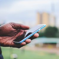 Close-up of a hand holding a smartphone outdoors — photo by Mwabonje Ringa on Pexels