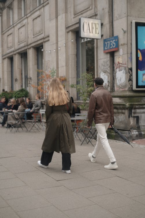 A Woman in Brown Coat Walking on Sidewalk