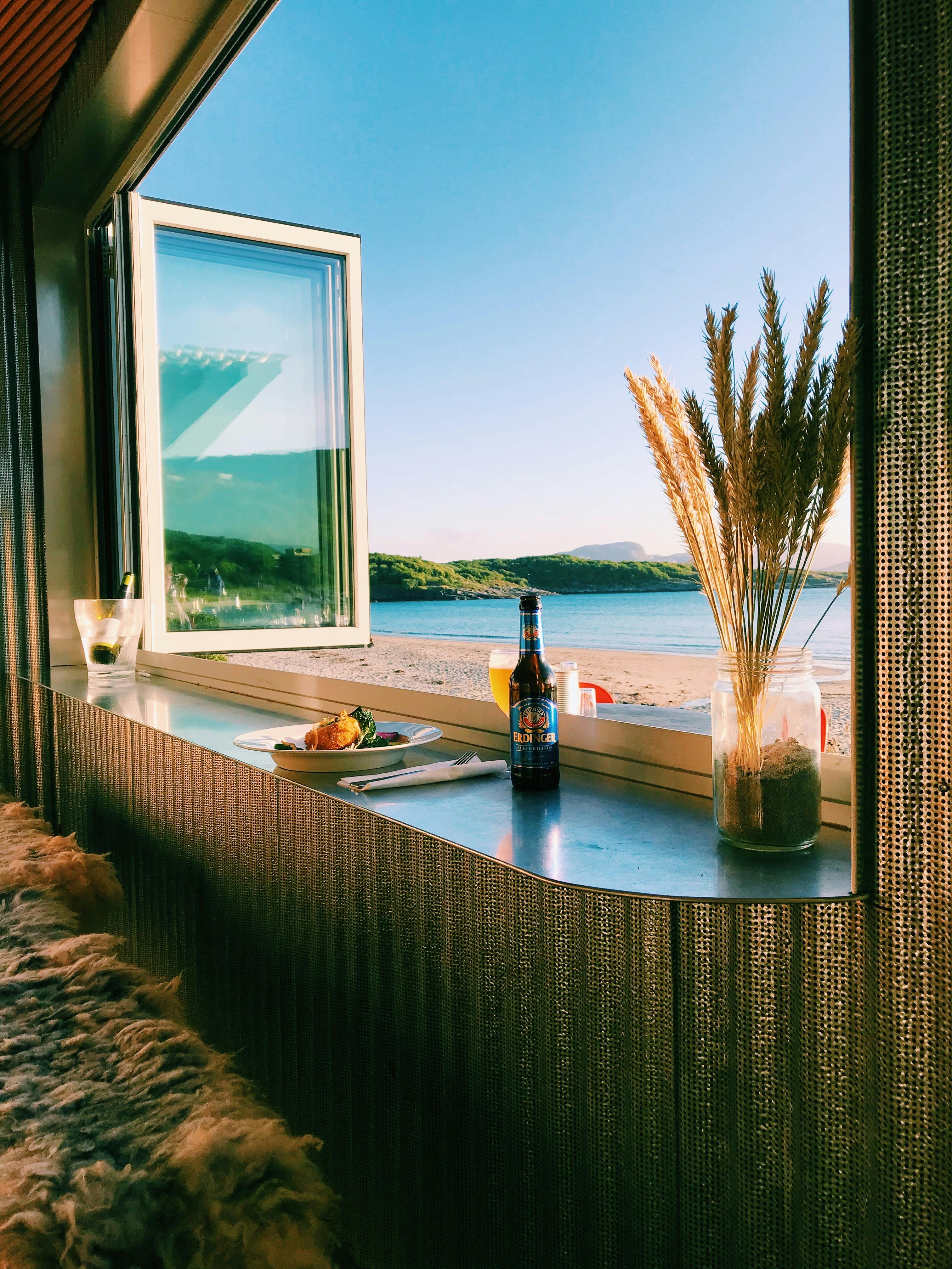 透过敞开的窗户，可以欣赏挪威海滩的宁静景色，并享用美食和饮料