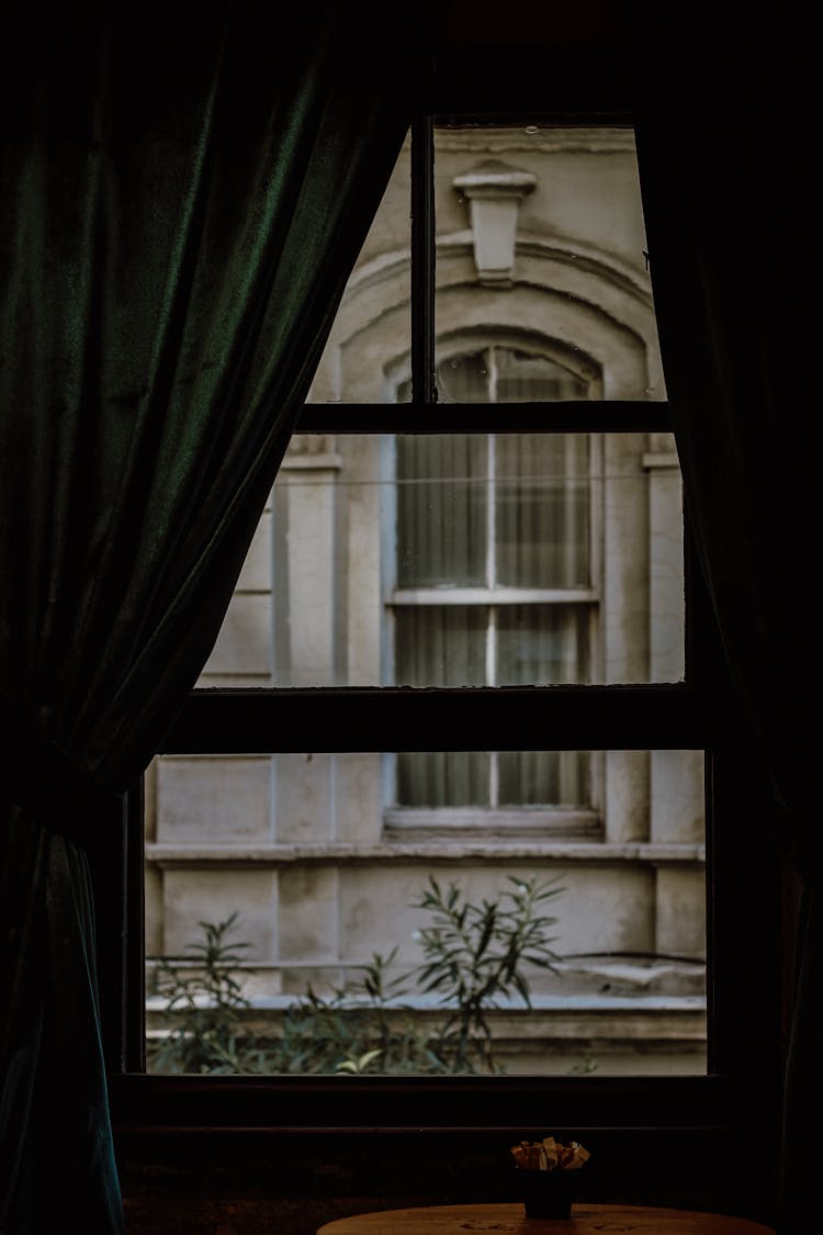 A Window With A Green Curtain