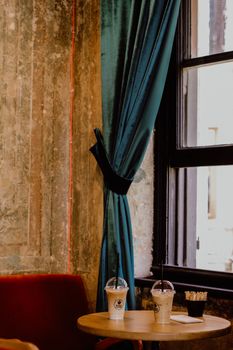 A stylish café setting in Istanbul with iced drinks on a table by a window, evoking a cozy vibe.