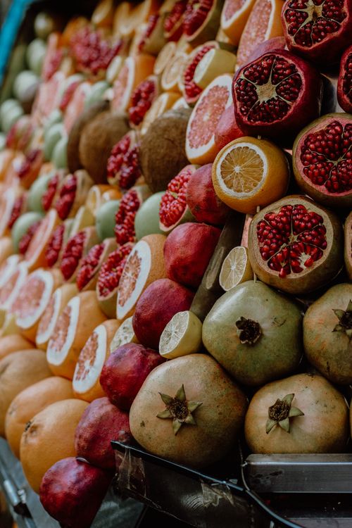 Free Colorful display of fresh pomegranates and citrus fruits at an Istanbul market stall. Stock Photo