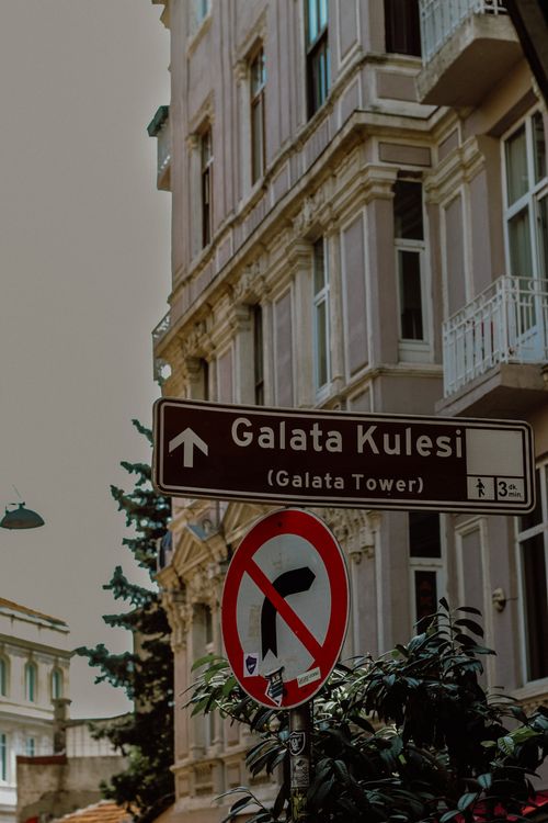 Free Street sign pointing to Galata Tower in Istanbul with residential buildings in the background. Stock Photo