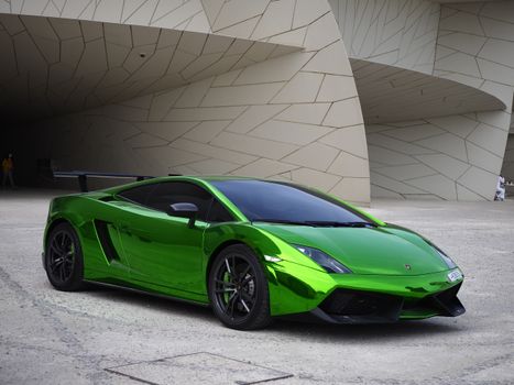 Shiny green sports car parked outside modern architecture in Doha, Qatar.