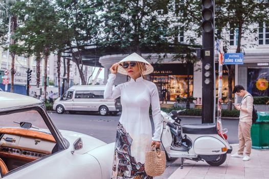 Stylish Asian woman in traditional Ao Dai at Đắk Ya, Gia Lai, highlighting Vietnamese street culture.
