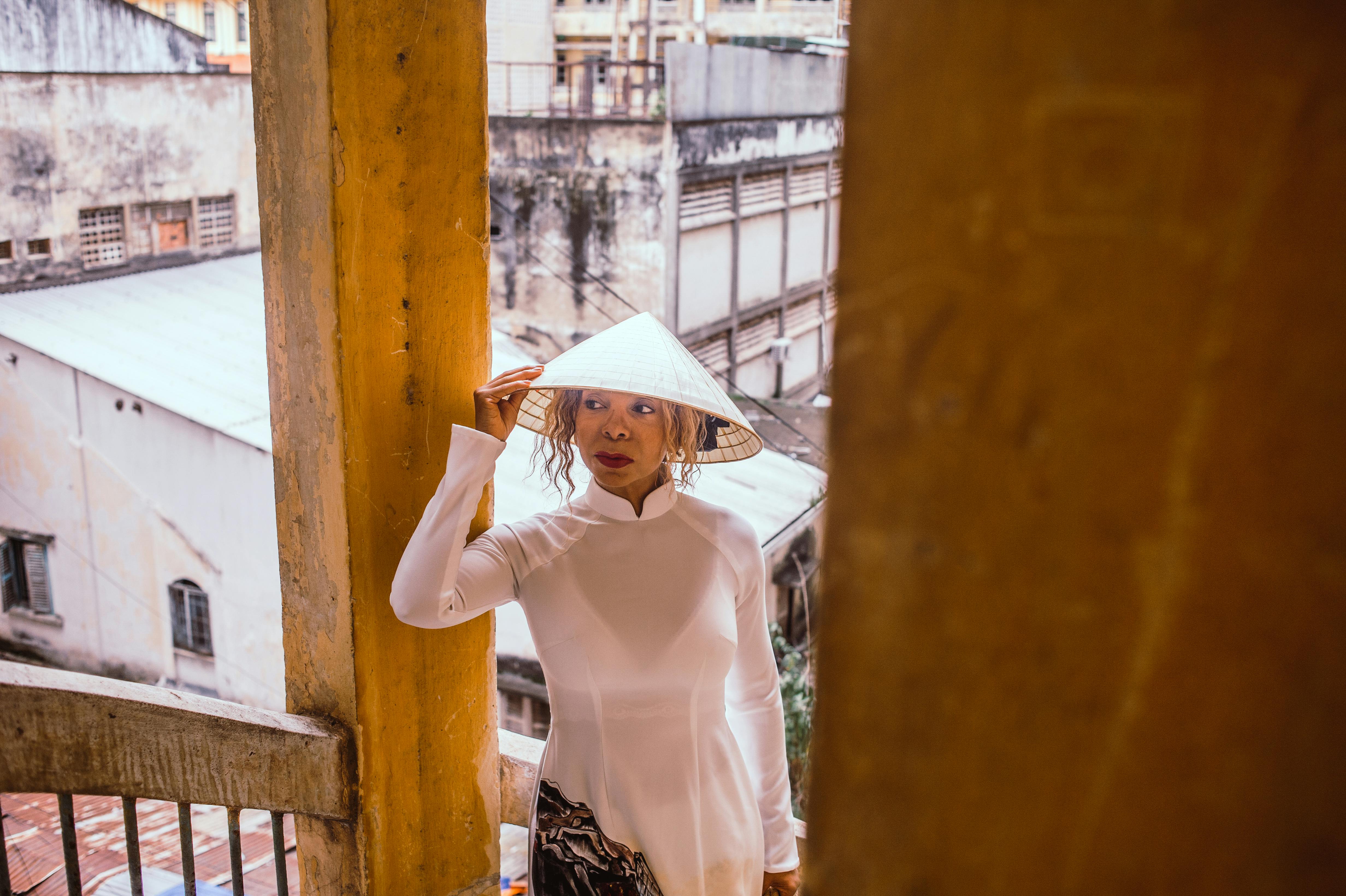 在越南胡志明市，身穿传统奥黛、头戴斗笠的妇女，展现了城市环境中的文化时尚