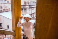 在越南胡志明市，身穿传统奥黛、头戴斗笠的妇女，展现了城市环境中的文化时尚