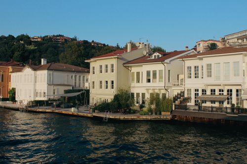 Free Charming waterfront houses along a peaceful coastal harbor, reflecting the elegance of seaside living. Stock Photo