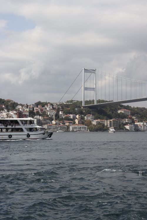 Free View of the Bosphorus Bridge in Istanbul with a ferry and residential buildings. Stock Photo