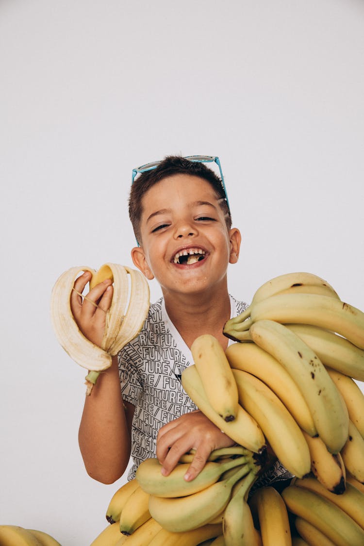 A Young Boy Eating A Banana Fruit