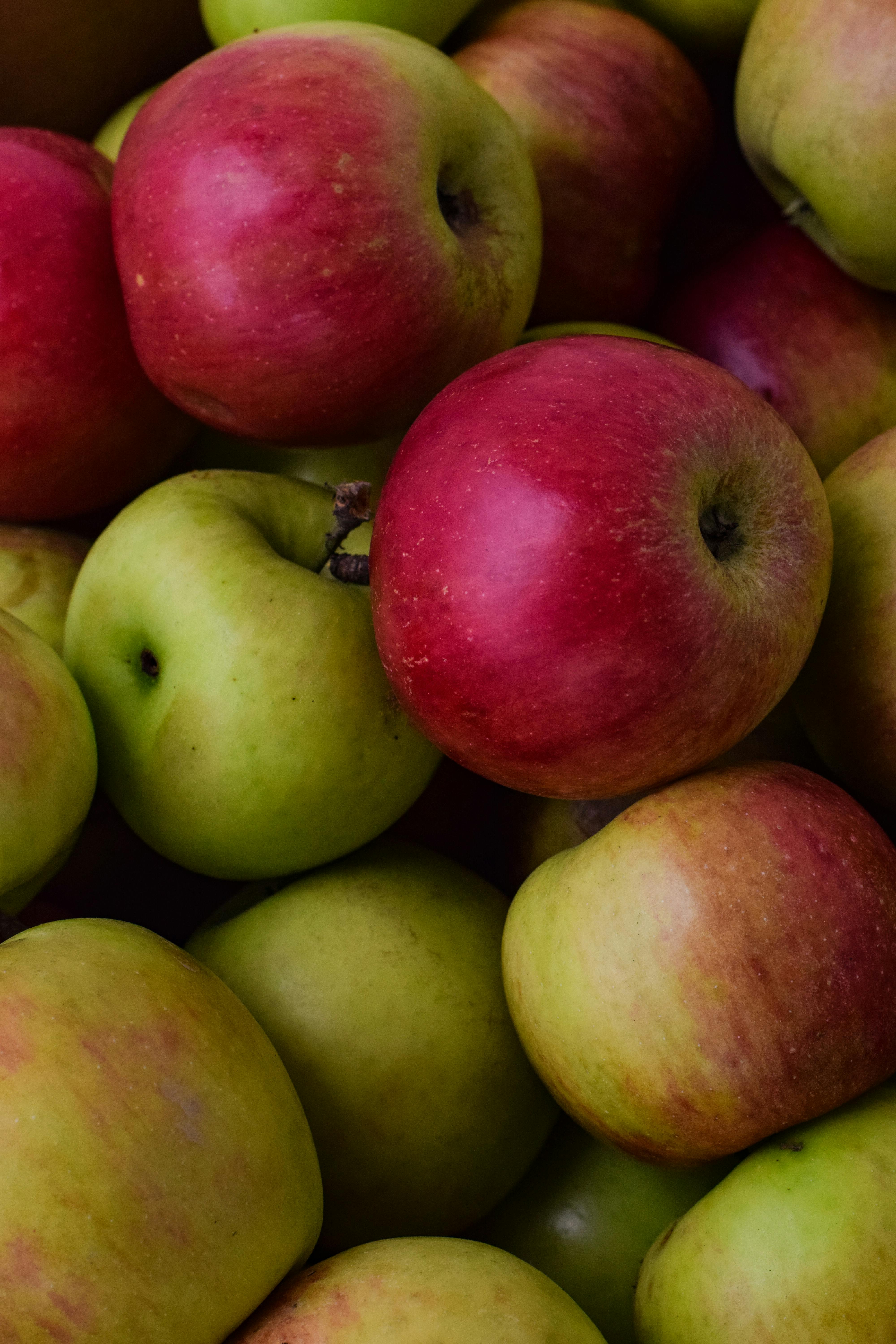 Red apple and green apple in basket with burlap background texture