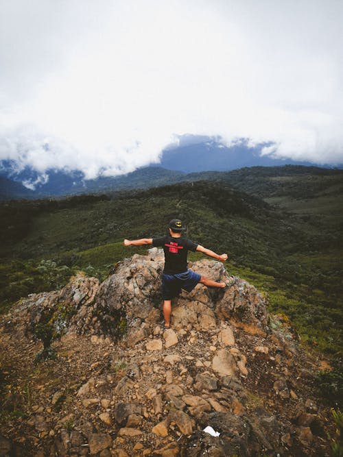 Male Hiker Standing on Top of a Rocky Hill