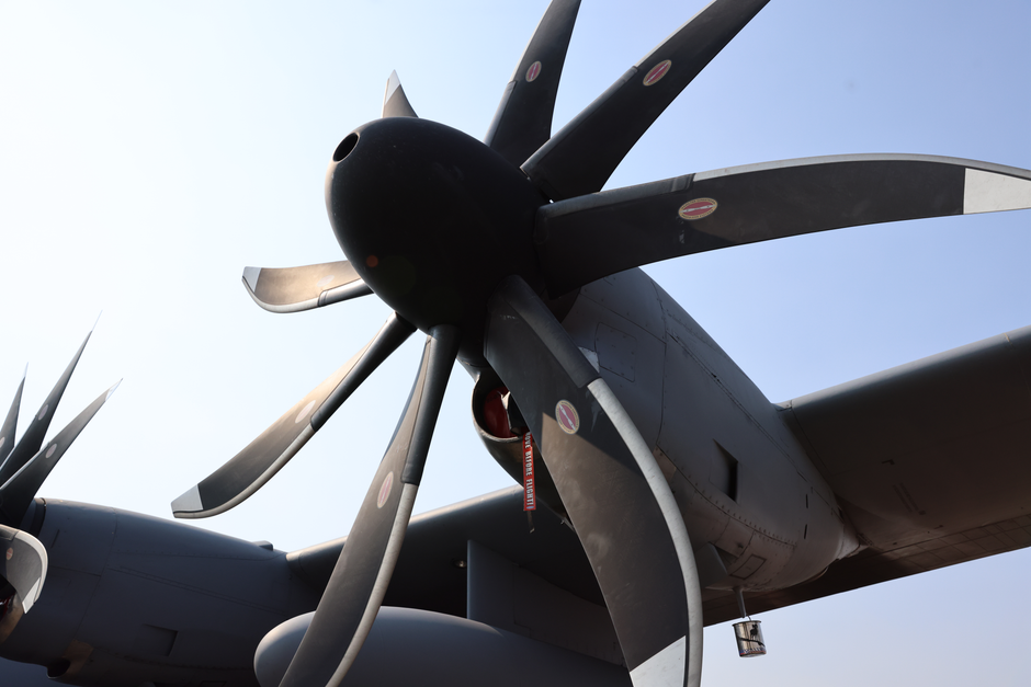 Detailed close-up of a large airplane propeller with a clear blue sky background, highlighting aviation technology.