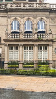 A detailed view of a historic stone building facade with balconies and decorative windows.