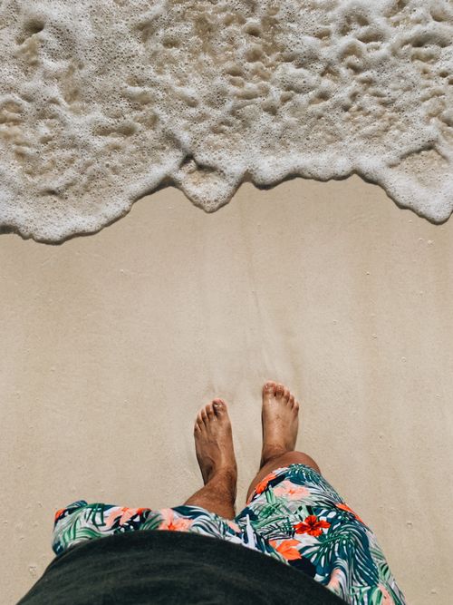 Free Feet on Cancún's sandy beach with seafoam waves gently lapping. Perfect for travel and leisure themes. Stock Photo