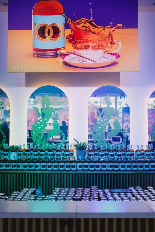 Free Modern bar with blue lights, diverse bottles, and artistic decor for a lively ambiance. Stock Photo