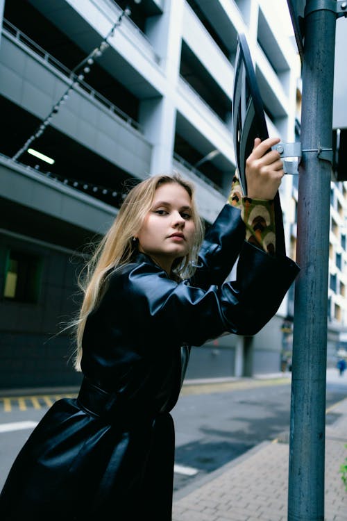 A Woman in Black Leather Jacket Posing at the Camera