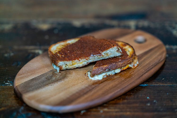 A Grilled Cheese Sandwich On A Wooden Board 