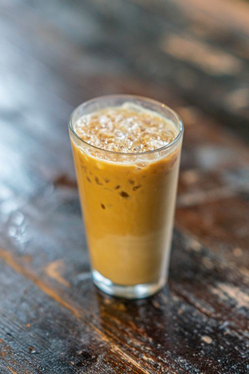 Free Close-up of a refreshing iced coffee in a glass on a rustic wooden table. Stock Photo