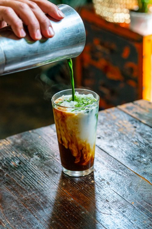 Free Colorful matcha latte blend being poured over ice in a glass. Refreshing and vibrant drink. Stock Photo