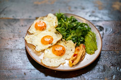 Free A Delicious Sunny Side Up Egg and Salad on a Plate Stock Photo