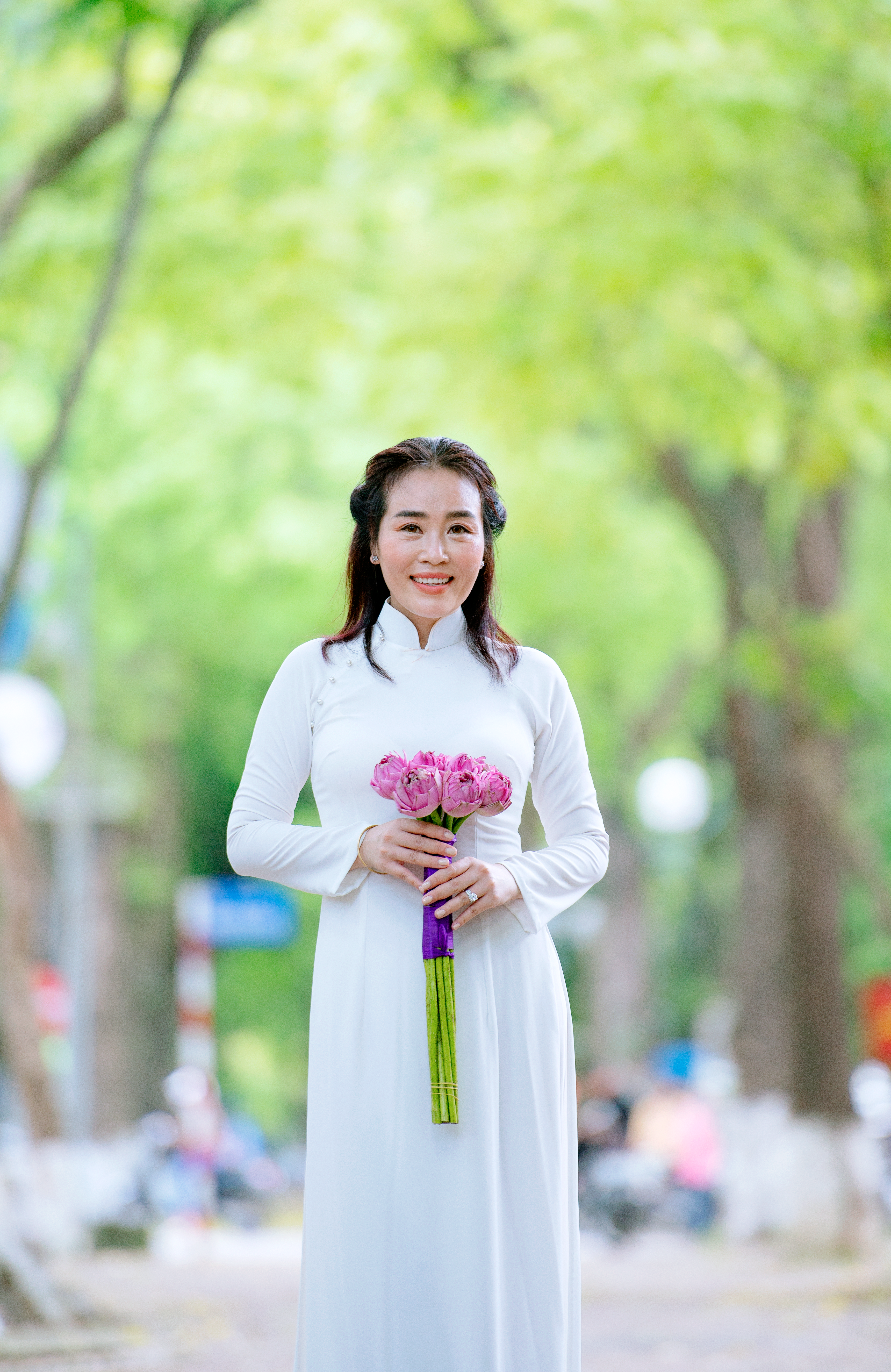 A Woman in White Dress Holding Pink Flowers · Free Stock Photo