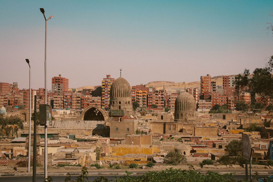 View of a cityscape blending ancient domed structures with modern buildings.