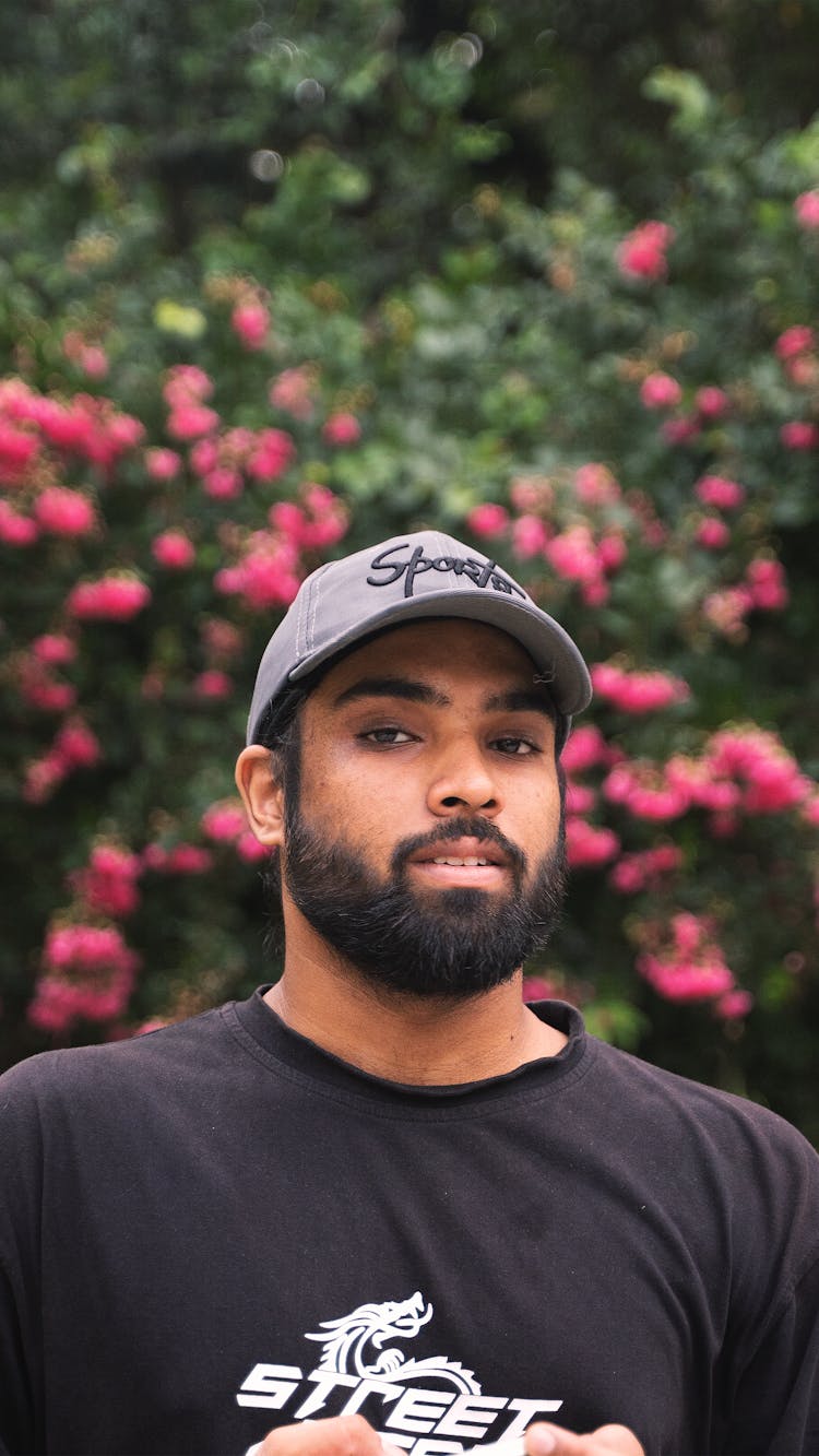 A Man In Black Crew Neck Shirt Wearing A Gray Cap