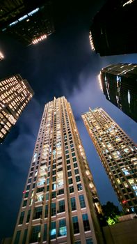 Stunning low angle shot of illuminated skyscrapers in Jakarta's urban center at night.