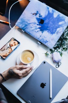 A stylish home office setup featuring tech gadgets and a coffee break.