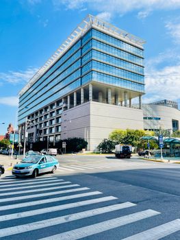 A striking modern building with glass windows in Tianjin's Bin Hai district, under a clear blue sky.