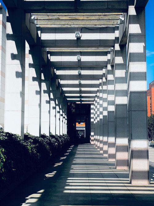 Free An architectural passage with columns casting dramatic shadows in Tianjin, China. Stock Photo