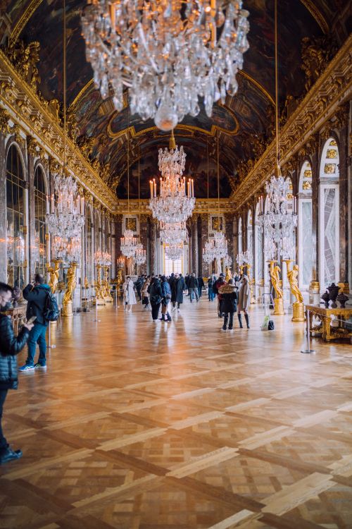 Free Opulent interior of the Hall of Mirrors with chandeliers and visitors in Versailles. Stock Photo
