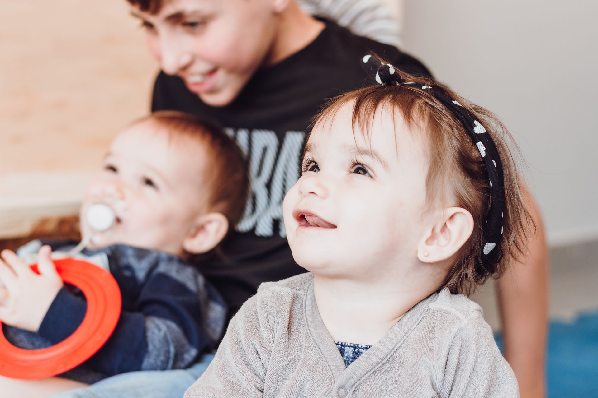 Joyful toddlers and sibling playing indoors, capturing love and innocence.